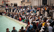 Crowds of visitors gather in front of the Trevi Fountain, one of the most popular tourist...