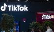 TikTok exhibition stand with the logo of the social media video platform illuminating whil...