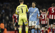 Rico Lewis #82 of Manchester City F.C. shakes hands with Joe Whitworth #1 of Exeter City F...