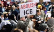 A protester holds a sign that reads, ''abolish ICE'' during a demonstration against Immigr...