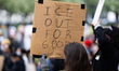 A protester holds a sign that reads, ''ICE out for good'' during a demonstration against I...