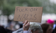 A protester holds a sign that reads, ''fuck off Nazis'' during a demonstration against Imm...