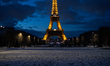 The view of the Eiffel Tower from the Champ de Mars gardens is covered in snow after heavy...