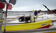 Small fishing boats rest on a snow-covered beach at the fishermen's harbour during winter...