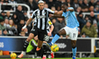 Joelinton of Newcastle United and Jeremy Doku of Manchester City battle for the ball durin...