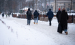 Pedestrians walk along a snow-covered pavement during heavy snowfall in central Warsaw, Po...