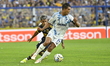 Exequiel Zeballos of Boca Juniors contests the ball with Mosquera of Millonarios of Colomb...