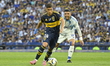 Miguel Merentiel of Boca Juniors contests the ball with Rodrigo Urena of Millonarios of Co...