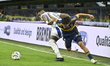 Exequiel Zeballos of Boca Juniors contests the ball with Mosquera of Millonarios of Colomb...