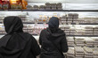 An Iranian woman stands in front of a shelf loaded with eggs while shopping for food produ...