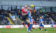 Robbie Cundy of Cheltenham Town and Joe Garner of Oldham Athletic challenge for a header d...