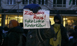 A sign reading ''ZioNazis Raus! Fake Linke KinderKiller!'' (''ZioNazis out! Fake left-wing...