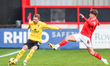 Ben Whitfield of Barrow AFC, wearing number 34, is in action with the ball as Max Sanders...