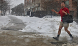 A man wears shorts as heavy snow falls during the winter season in Markham, Ontario, Canad...
