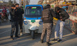 Kashmiri photojournalists take pictures as an Indian security personnel frisks a civilian...