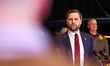 U.S. Vice President JD Vance gives a press conference while standing in front of ICE agent...