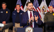 U.S. Vice President JD Vance gives a press conference while standing in front of ICE agent...