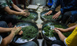 In Xian of Mingshan, Sichuan Province, China, on April 13, 2025, men hand-roast freshly pi...