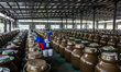 In Chengdu, China, on April 14, 2025, workers drain water from large earthenware jars in a...
