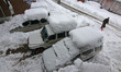 In Shopian, Jammu and Kashmir, India, on January 23, 2026, vehicles are covered in heavy s...