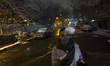 A young Iranian woman plays with a snowball at the end of a snowy day in downtown Tehran,...