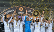 Al Sadd SC players celebrate with the trophy on the podium after winning the Qatar-UAE Sup...