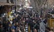 Iranian shoppers walk along a sidewalk outside the Grand Bazaar in southern Tehran, Iran,...