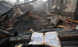 A fire-stricken book lies on the ruins at the Holy Dormition Male Monastery after the Russ...