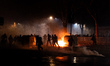 Near the evicted building, people clash with riot police, which uses water cannons and tea...
