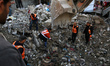 Civil defence teams search for the bodies of the Salem family under the rubble of their ho...
