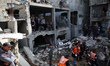 Civil defence teams search for the bodies of the Salem family under the rubble of their ho...