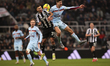 Vitaly Janelt of Brentford wins a header against Bruno Guimaraes during the Premier League...