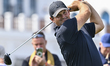 Patrick Reed of the United States tees off on the first hole during round four of the Qata...