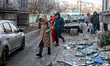 People cross a street covered with shattered glass after an overnight Russian drone strike...