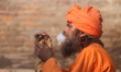 A sadhu, a Hindu holy person, smokes marijuana from a traditional chillum on the eve of th...