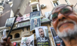 A large banner depicting President Kais Saied in a police and judge uniform, bearing the A...