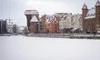 Historic waterfront buildings line the frozen Motlawa with the Gdansk Crane (Zuraw) visibl...