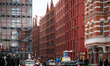 A winter street view shows Chmielna Street on Granary Island with newly built buildings de...