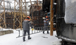 Workers from Kharkivoblenerho carry a ladder during repair works at an energy facility dam...