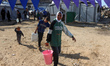 Palestinians fill up water containers from a mobile cistern in Gaza City, Palestine, on Fe...