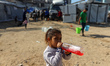A Palestinian girl drinks juice outside her family's tent in Gaza City, Palestine, on Febr...