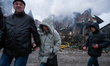 People walk past a house destroyed by a Russian attack in Sofiivska Borshchahivka village,...