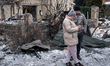 A man and a woman stand outside a house damaged by a massive Russian attack in Sofiivska B...
