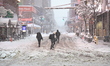 People brave the blizzard conditions as heavy snow falls on Seventh Avenue in New York, Un...