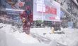 A person shovels snow in Times Square in Manhattan as blizzard conditions persist for a se...