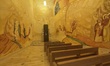 Murals illustrating biblical scenes decorate an interior space near a chapel entrance insi...