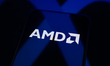 The AMD logo appears on a smartphone screen placed on a reflective surface onto which a Me...