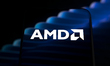 The AMD logo appears on a smartphone screen placed on a reflective surface onto which a bl...