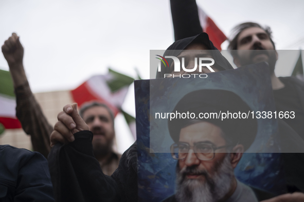 A veiled Iranian woman holds a portrait of Iran's Supreme Leader, Ayatollah Ali Khamenei during an anti-war protest against the U.S. and Isr... by Morteza Nikoubazl/NurPhoto