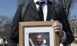 A demonstrator holds a framed portrait of Alex Jeffrey Pretti during the ''March 4 Democra...